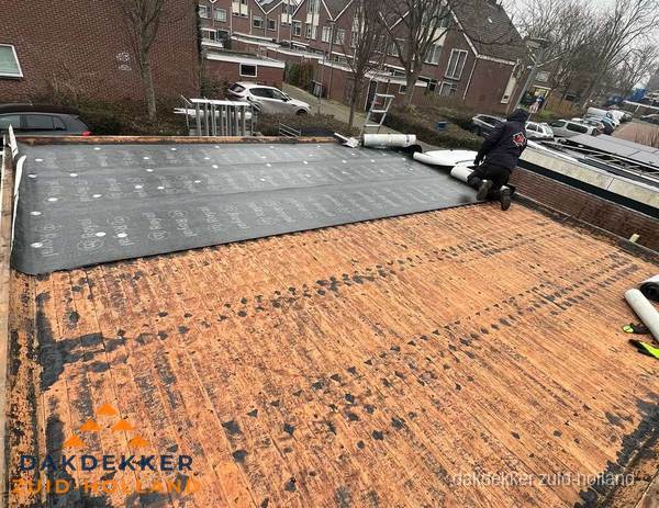 Dakdekker legt onderlaag op plat dak met houten constructie in Zuid-Holland Dakdekker legt onderlaag op plat dak met houten constructie in Zuid-Holland